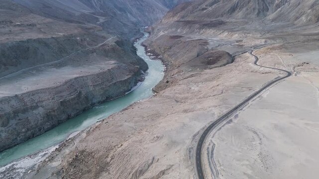 Aerial Descending Shot of Winding Karakoram Highway and Indus River 4K, Parallel Paths: The Sinuous Dance of Asphalt and Water in the Himalaya