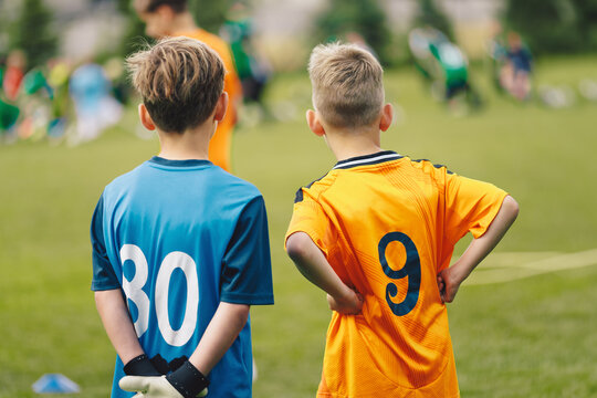 Young Soccer Players Watching Match; Kids in Football Jerseys Observing Game, Youth Inspiration, Learning and Team Spirit in Sports