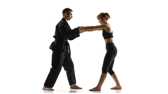 Man and woman practicing hand control technique during martial arts training session. Concept of coordination training, controlled movement, partner interaction, skill development in combat practice.
