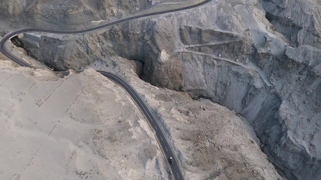 Aerial Forward Drone Shot of S-Curve on Karakoram Highway with Moving Vehicle 4K, A Solitary Transport Van Navigating the Rugged Himalayan Wilderness