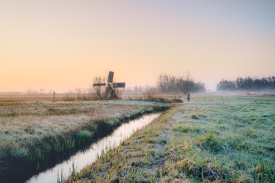 Golden dawn light kisses frosted fields and quiet canals.
