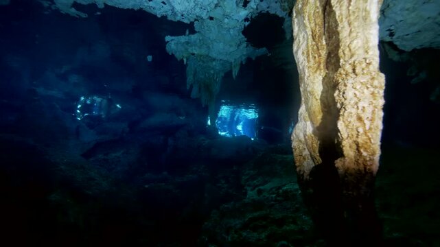 Column and reflective water surface form symmetrical composition in cenote cavern in Cenote Dos Ojos, Quintana Roo, Mexico