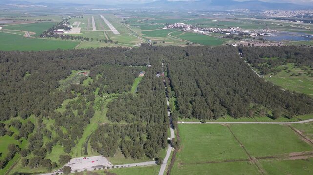 Aerial footage showing Sasali Natural Life Park at İzmir , with a nearby airport runway and green fields, oe01