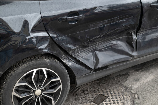 Damaged car door after collision with dents and scratches, auto accident and insurance claim concept
