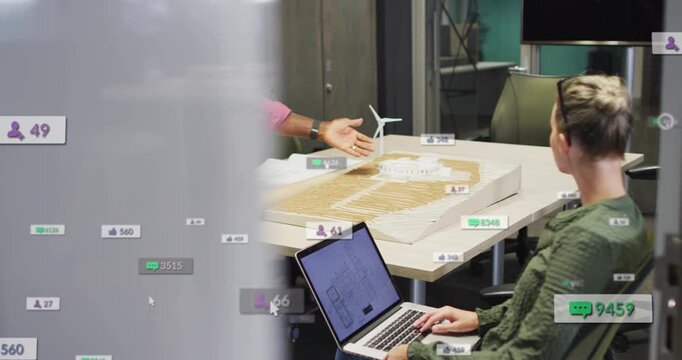 Camera shifting revealing design model and UI during review, lead gesturing, woman using laptop
