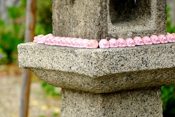日本の神社に並ぶ可愛いピンクのうさぎと伝統的な石灯籠 © taka
