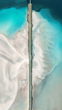 Aerial view sea divided by road line scenery from above in Lofoten islands travel in Norway, minimal natural background with symmetry geometric and unique perspective in scenic summer landscape