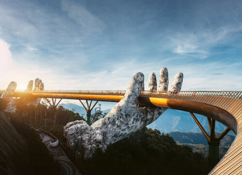 Vietnam travel destination Golden Bridge in Ba Na Hills near Da Nang. Famous landmark with giant hands holding a footbridge above mountains, popular sightseeing location