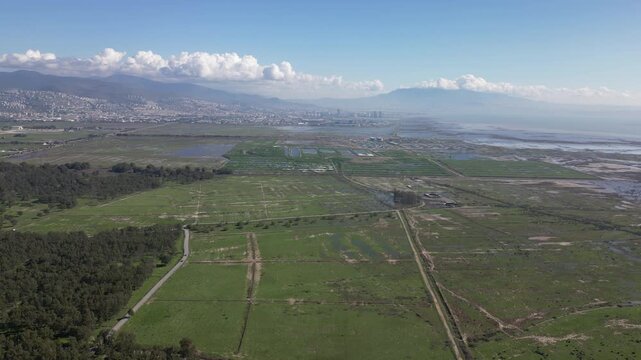 Aerial footage showing Sasali Natural Life Park at İzmir , with a nearby airport runway and green fields, oe01