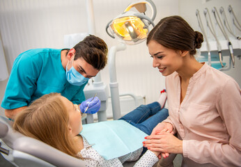 Obraz premium Child dental checkup with mother and dentist.