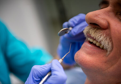 Close-up dental examination of senior patient.