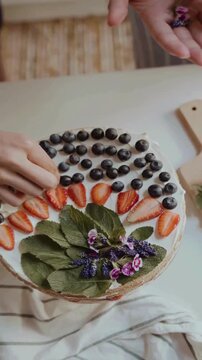 Hand Decorating Cake Tart With Fresh Strawberry, Blackcurrant and Mint Leaves &ndash; Gourmet Dessert Topping Close Up