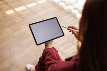 Naklejka premium Woman using digital tablet with stylus blank screen