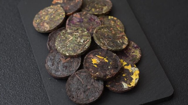 Organic Chinese green pu-erh tea with various herbs in round bricks. Chinese pu-erh tea as a background for your design