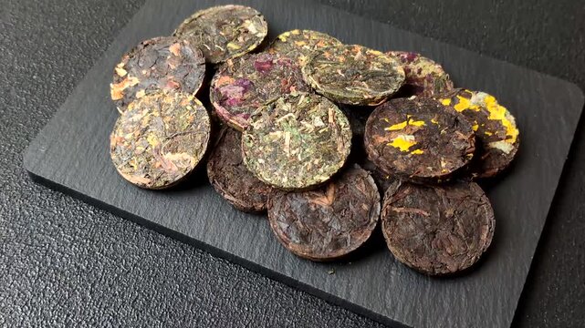 Organic Chinese green pu-erh tea with various herbs in round bricks. Chinese pu-erh tea as a background for your design