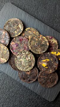 Organic Chinese green pu-erh tea with various herbs in round bricks. Chinese pu-erh tea as a background for your design