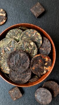 Organic Chinese green pu-erh tea with various herbs in round bricks. Chinese pu-erh tea as a background for your design