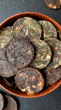 Organic Chinese green pu-erh tea with various herbs in round bricks. Chinese pu-erh tea as a background for your design