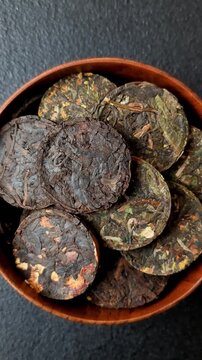 Organic Chinese green pu-erh tea with various herbs in round bricks. Chinese pu-erh tea as a background for your design