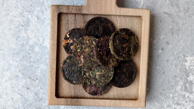 Organic Chinese green pu-erh tea with various herbs in round bricks. Chinese pu-erh tea as a background for your design