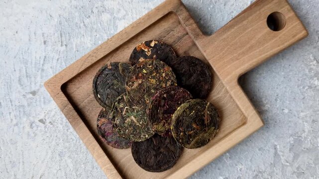 Organic Chinese green pu-erh tea with various herbs in round bricks. Chinese pu-erh tea as a background for your design
