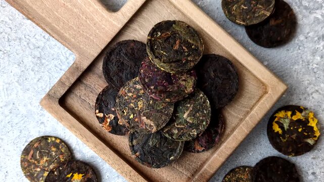 Organic Chinese green pu-erh tea with various herbs in round bricks. Chinese pu-erh tea as a background for your design