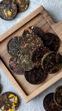 Organic Chinese green pu-erh tea with various herbs in round bricks. Chinese pu-erh tea as a background for your design