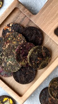 Organic Chinese green pu-erh tea with various herbs in round bricks. Chinese pu-erh tea as a background for your design