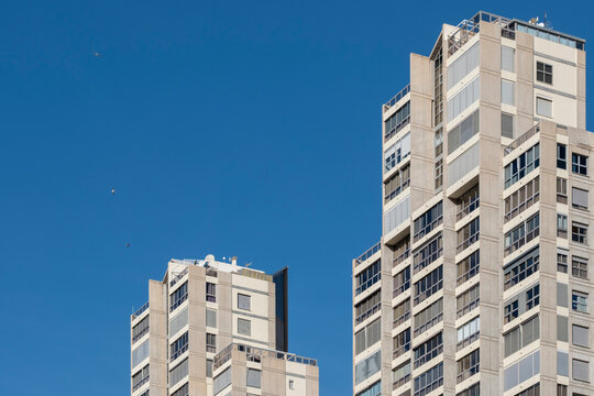 Skyline in spain with minimal blue space as urban highrise towers and buildings frame apartments architecture and a stark facade composition