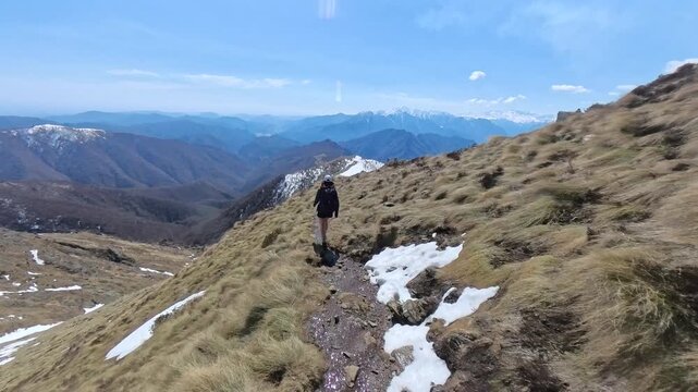 Massa del turlo, valsesia, valle strona, Italy - April: a girl hiking to the top of the mountain in a sunny day
