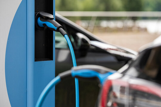 Clean commercial detail of charging electric cable connector and plug on vehicle at station for transport in Berlin Germany energy mobility