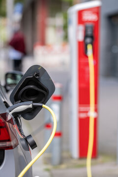 Commercial close view of charging electric vehicle cable and plug at station showing energy transport infrastructure in Hamburg Germany