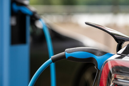 Commercial closeup of charging electric cable and connector on vehicle plug at station for transport in Berlin Germany clean modern infrastructure