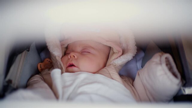 Close up of a sleeping baby with pacifier in a stroller