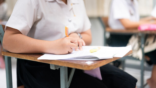 Students Taking Exam in Classroom Focused on Writing