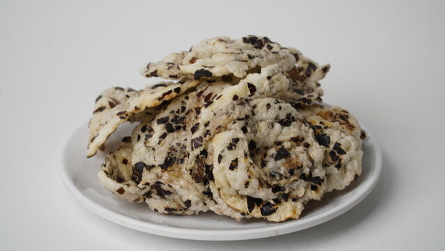 Tike chips or keripik tike, a traditional snack from Indramayu, Indonesia, made from nutgrass tubers, served on a white plate.