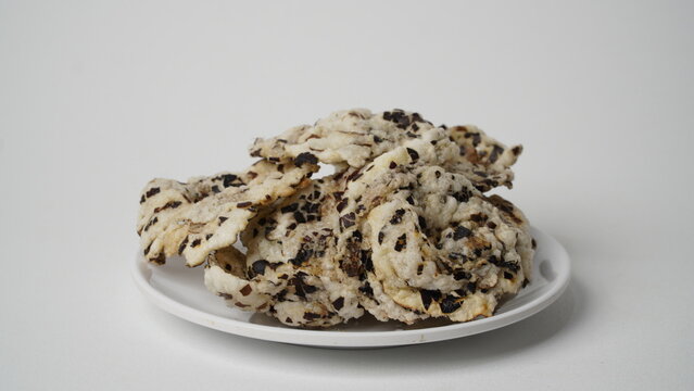 Tike chips or keripik tike, a traditional snack from Indramayu, Indonesia, made from nutgrass tubers, served on a white plate.