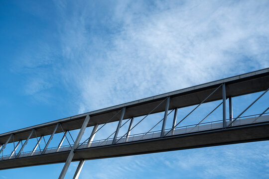 Linear skybridge walkway with truss glass and sky as abstract architecture showing modern minimal structure and disciplined geometry