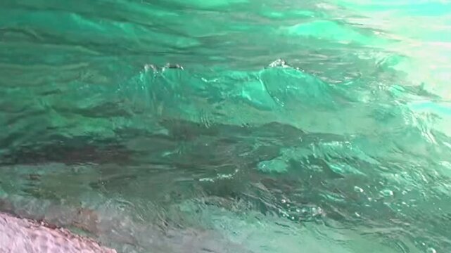 Vibrant turquoise water gently glides against smooth, sculpted walls of Patagonia Marble Caves. Sunlight dances across unique rock formations, revealing intricate patterns and serene natural artistry.
