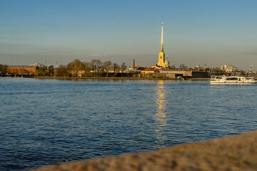 Fototapeta premium Peter and Paul Fortress across Neva River at sunset with boat, Saint Petersburg