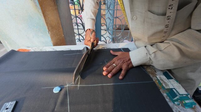 Professional tailor cutting fabric with shears Indian workshop 4k video footage.