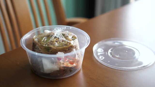 Traditional Phuket Sapam noodles (Hokkien noodles) in plastic takeaway container for street food and delivery service concept
