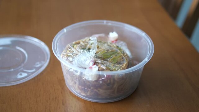 Traditional Phuket Sapam noodles (Hokkien noodles) in plastic takeaway container for street food and delivery service concept