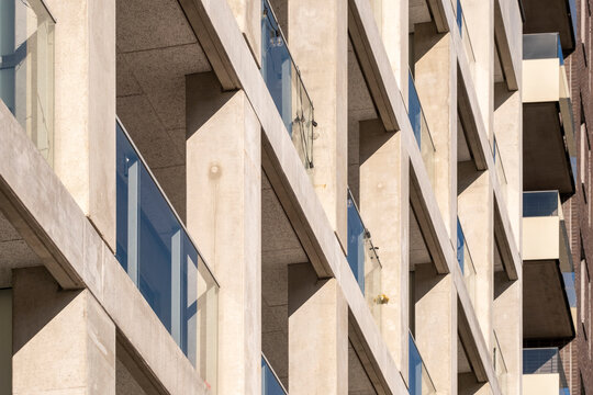 Urban modern architecture detail with concrete facade balconies and geometric repetition of windows creating patterned structure and rhythmic design