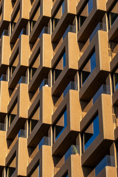 Golden wood texture on modern architecture facade with geometric pattern and windows highlighting texture detail surface design and warm rhythm