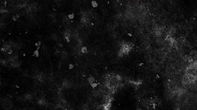 4K Cinematic dark grunge texture overlay featuring scattered chunky dust spots, cloudy smudges, and mottled grain on a black background for VFX compositing.