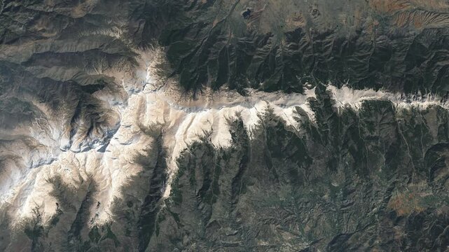 Aerial perspective on  mountain ridge covered with snow. Camera is zooming in, rotating counterclockwise. Animation based on image by NASA