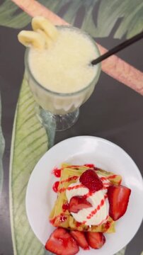 wafles con crema y frutilla y licuado de banana