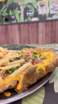 milanesa con cheddar panceta crocante y verdeo con papas fritas