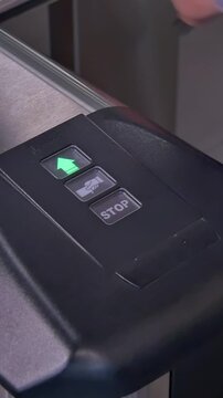 A hand gracefully inserts an access card into the sleek automated barrier control panel.